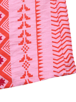Pink midi dress with red geometric pattern, halter neck, and slit detail.