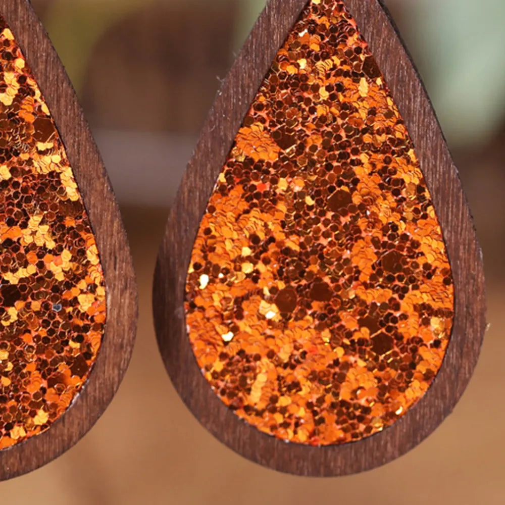 Wood-framed glitter teardrop earrings in caramel with a sparkly finish.