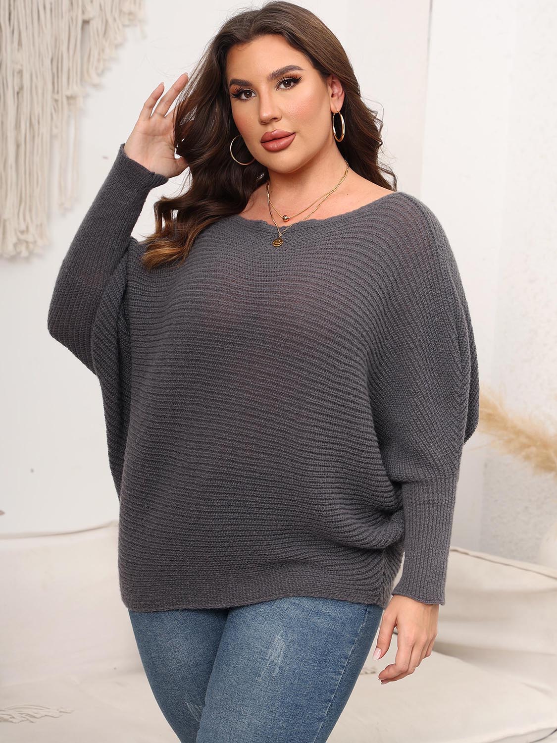 Charcoal ribbed knit off-shoulder sweater with batwing sleeves and a boat neckline.