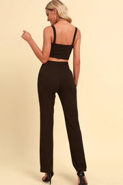 Black chain strap crop top and high-waist trousers outfit set.