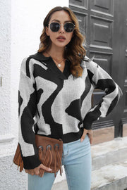 Women's black and white abstract print knit polo sweater with long sleeves.