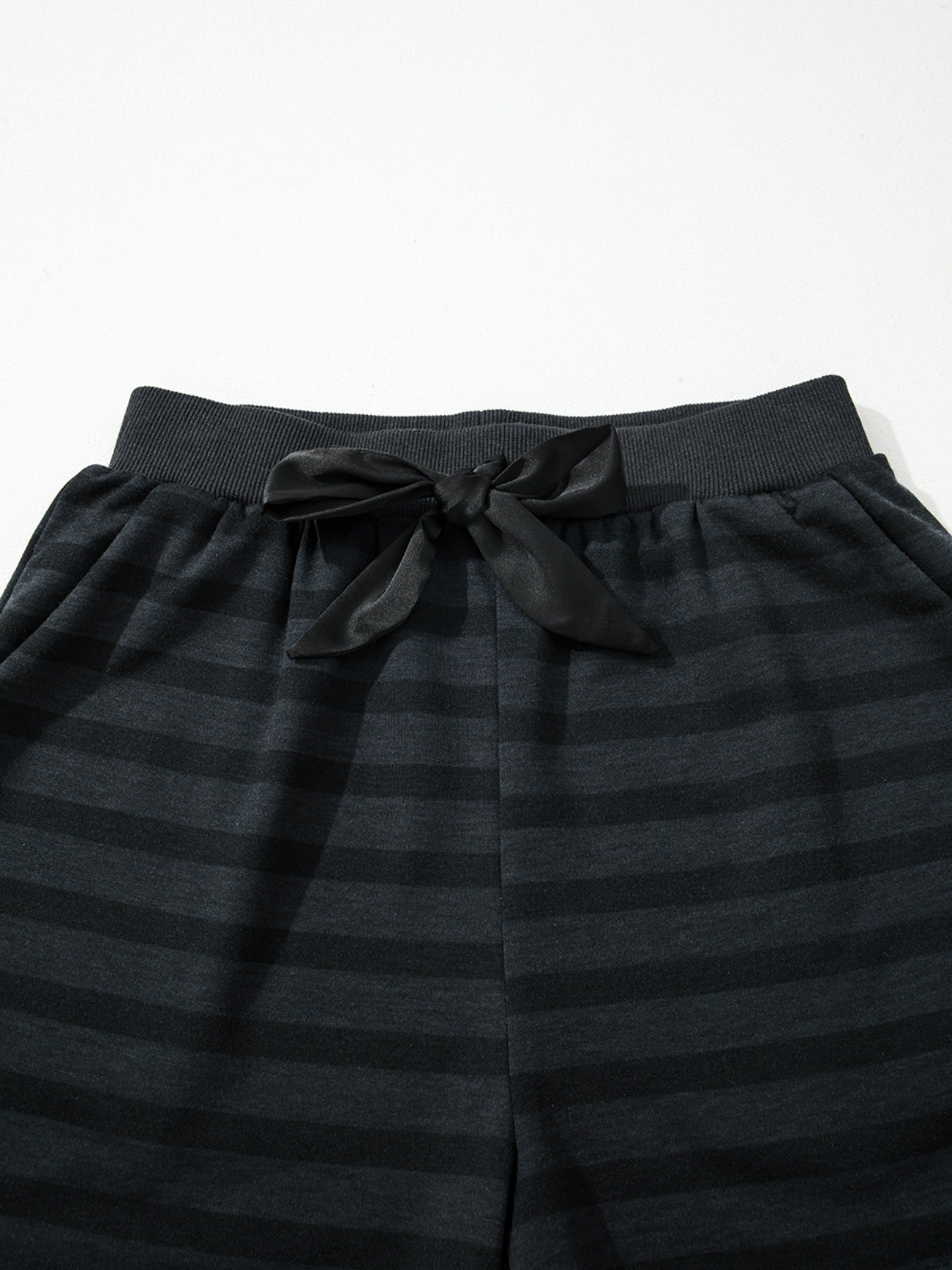 Dark gray striped pajama shorts with elastic waistband and black satin bow detail.