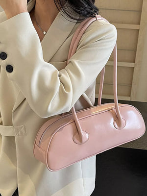 Pink pu leather shoulder bag with minimalist design and top zipper closure.