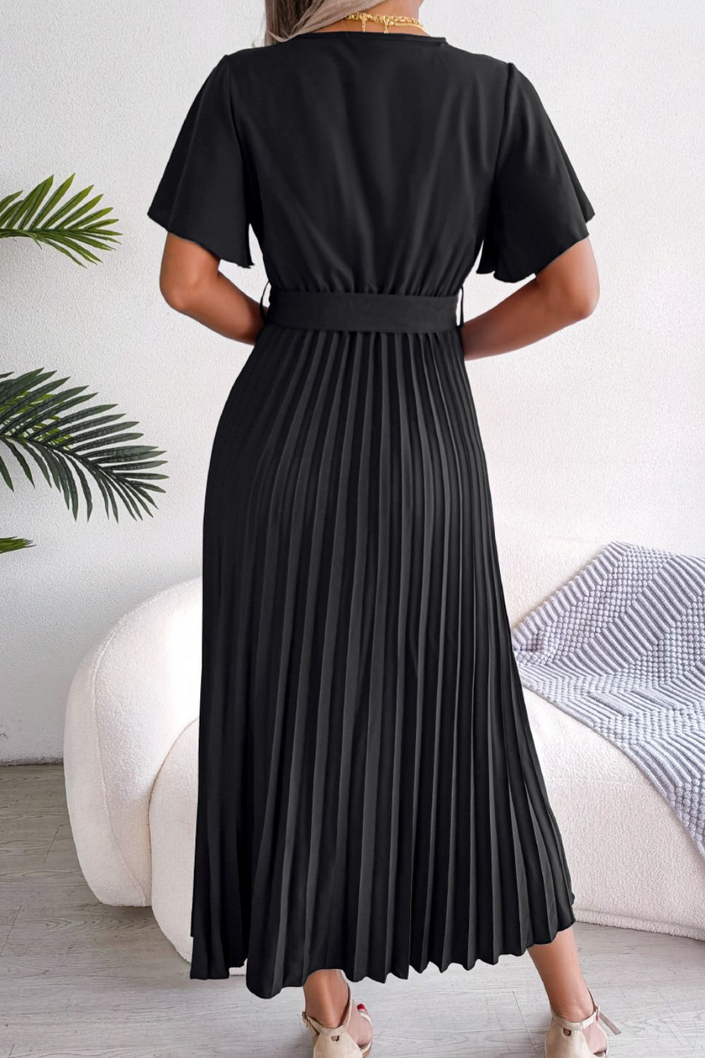 Black wrap bodice midi dress with short flutter sleeves and a pleated skirt.