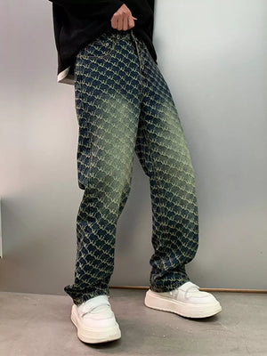 Men's relaxed fit jeans with all-over woven motif pattern in blue and green wash cotton.