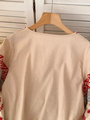 Apricot embroidered folk shirt with tie neck and detailed sleeves.