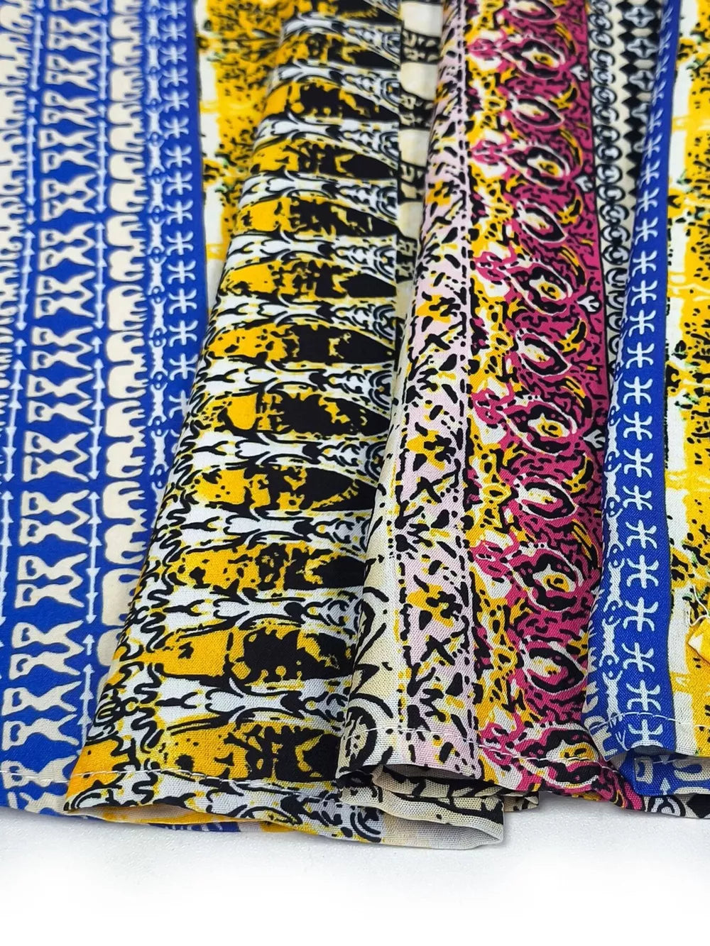 Bohemian maxi dress fabric detail in yellow, blue, and pink abstract patterns.