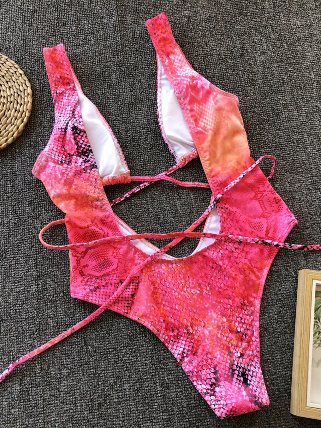 Snakeskin plunge swimsuit in hot pink with crisscross back straps and a deep V-neck.