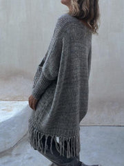 Dark gray knit poncho sweater with fringe hem and pockets.