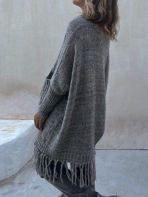 Dark gray knit poncho sweater with fringe hem and pockets.