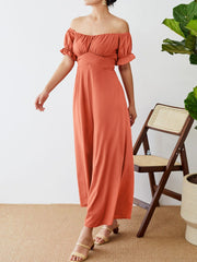 Coral off-the-shoulder jumpsuit with ruched waist and puff sleeves.