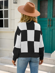 Black and white checkerboard knit pullover sweater with balloon sleeves.