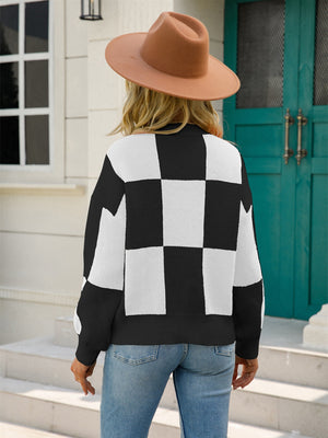 Black and white checkerboard knit pullover sweater with balloon sleeves.