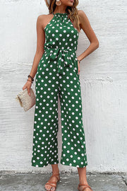 Green polka dot halter neck palazzo jumpsuit with tie waist and wide legs.