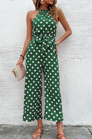 Green polka dot halter neck palazzo jumpsuit with tie waist and wide legs.