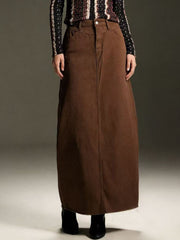 Brown denim maxi skirt with raw hem and button closure.