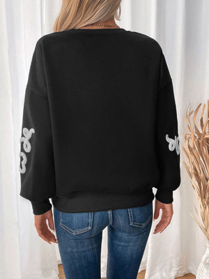 Black sweatshirt with embroidered heart detail on sleeves
