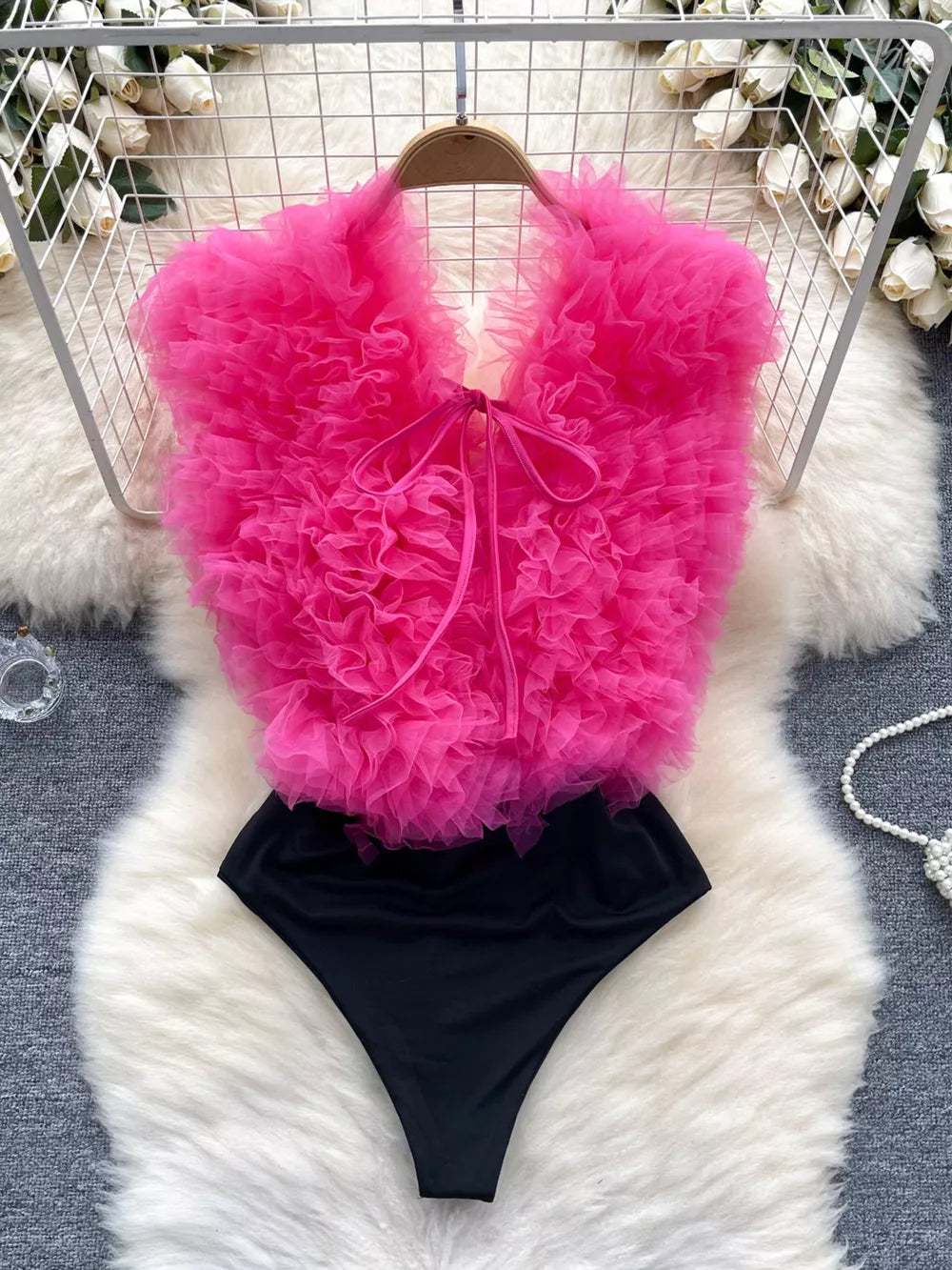 Pink ruffled V-neck bodysuit with lace detail and tie front
