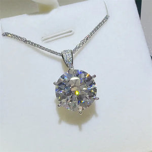 Silver moissanite solitaire pendant with a sparkling round-cut stone and diamond-accented bail.
