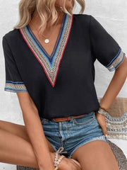 Black V-neck top with colorful embroidered trim on neckline and sleeves.