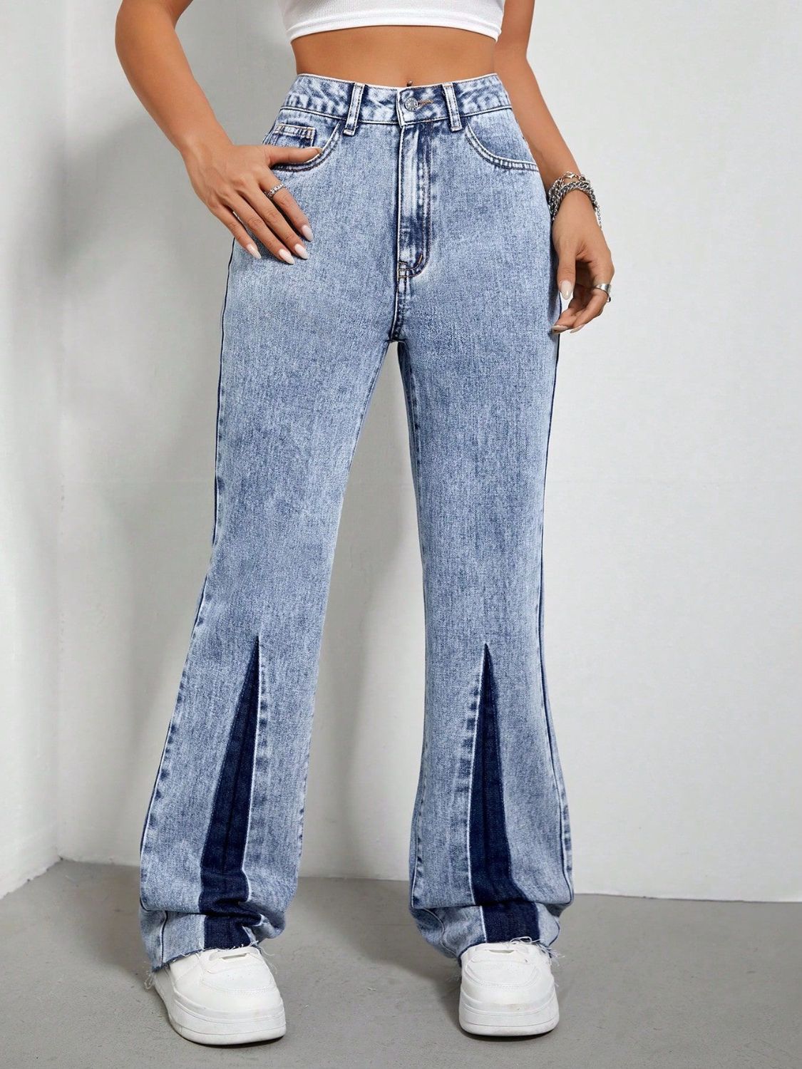 Light acid wash bootcut jeans with split hems and dark blue denim insets.