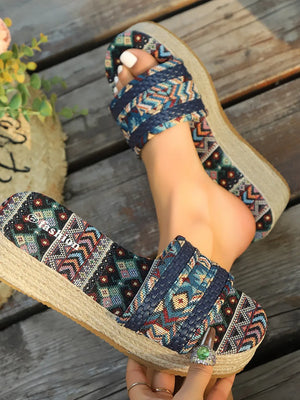 Woven platform slides with geometric pattern and espadrille sole.