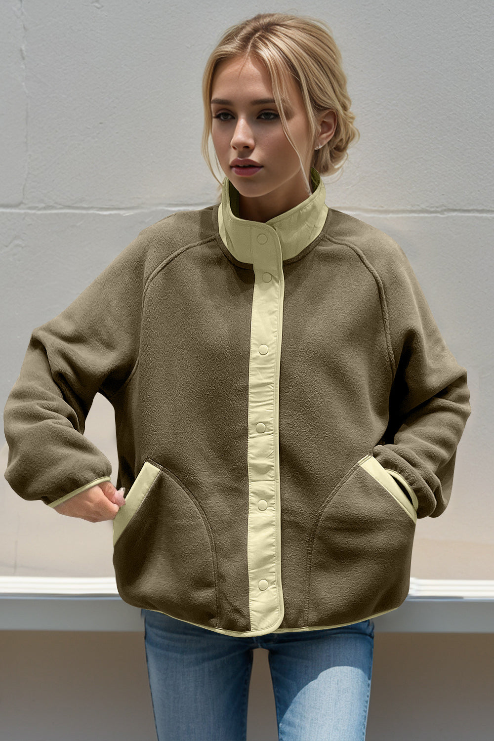 Moss fleece bomber jacket with cream contrast trim and snap button closure.