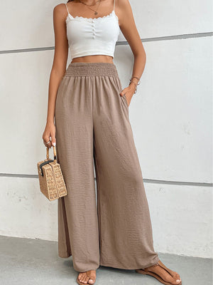 Brown textured smocked waist palazzo maternity trousers with wide legs and pockets.
