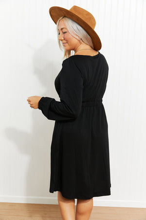 Black button-down empire waist mini dress with long balloon sleeves and elastic waist