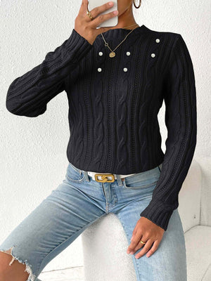 Black cable knit sweater with pearl embellishments and a mock neck.