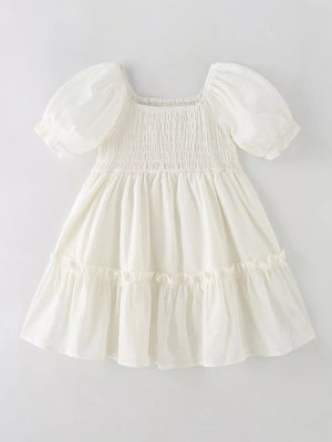 Cream cotton blend toddler dress with puff sleeves, square neckline, smocked bodice, and tiered ruffle skirt.