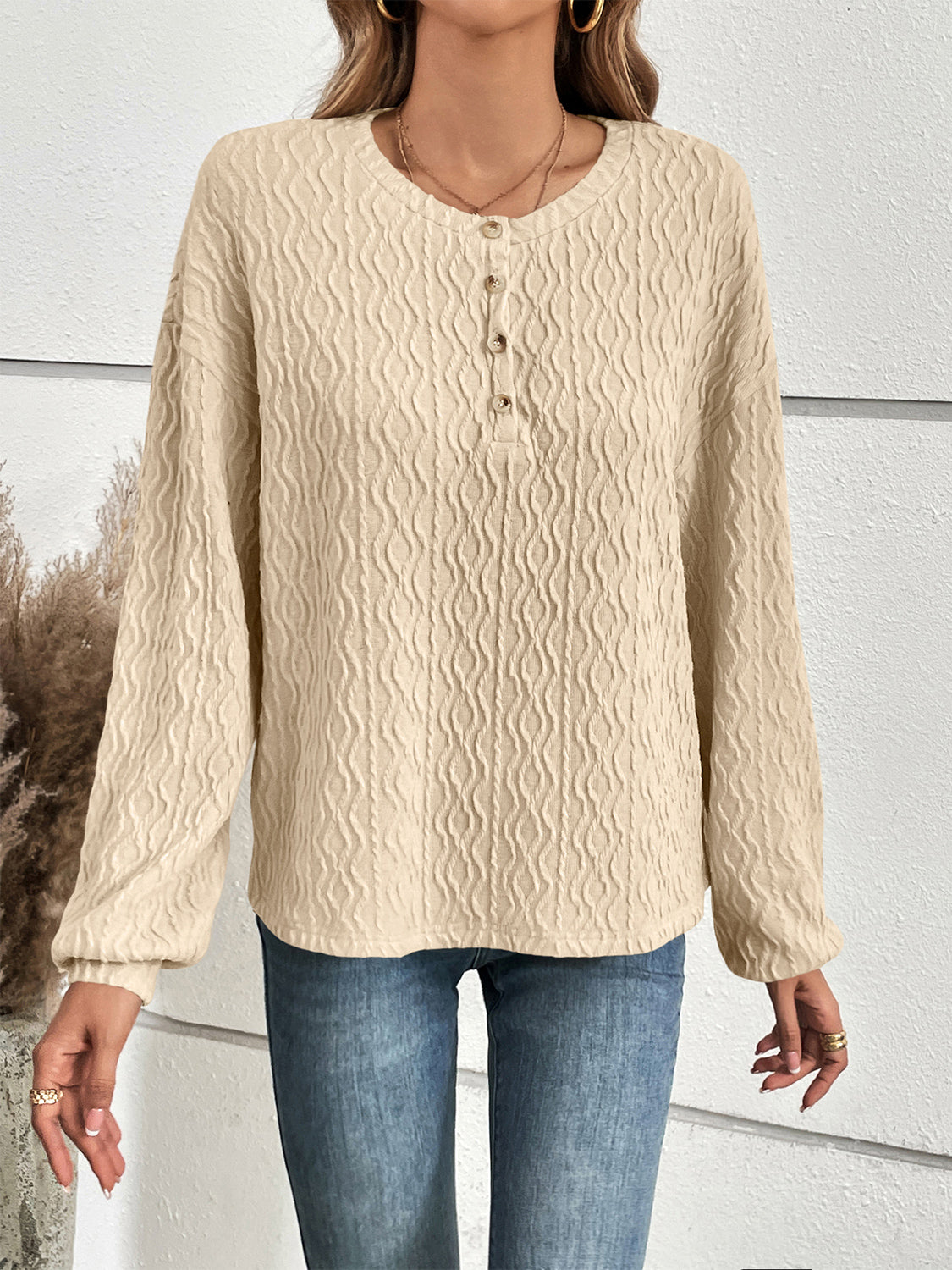 Textured ivory henley blouse with button detail and blouson sleeves.