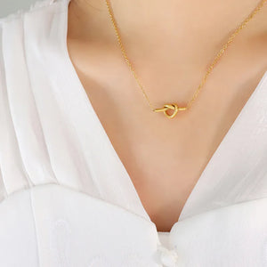 Gold tied bar pendant necklace with delicate chain.