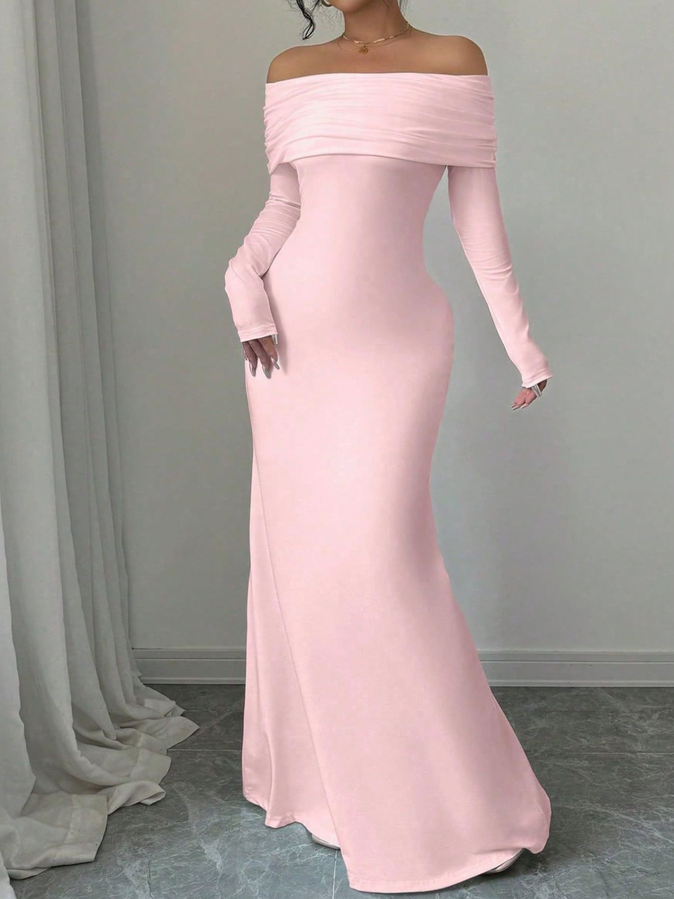 Dusty pink bodycon maxi dress with draped off-shoulder neckline and long sleeves.