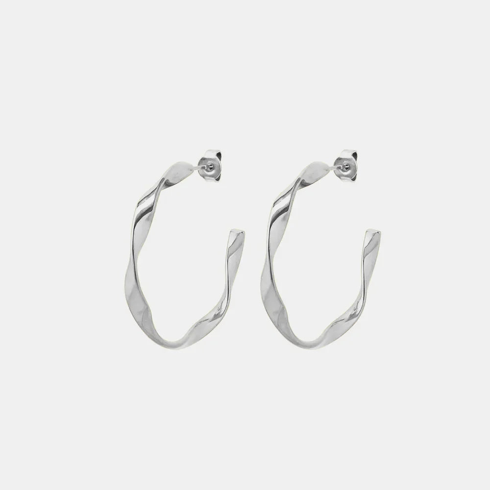 Sculpted silver twist hoop earrings with a modern, chic design.