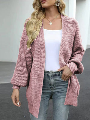 Chunky knit cocoon cardigan in dusty pink with balloon sleeves and an open front, worn over a white top and jeans.