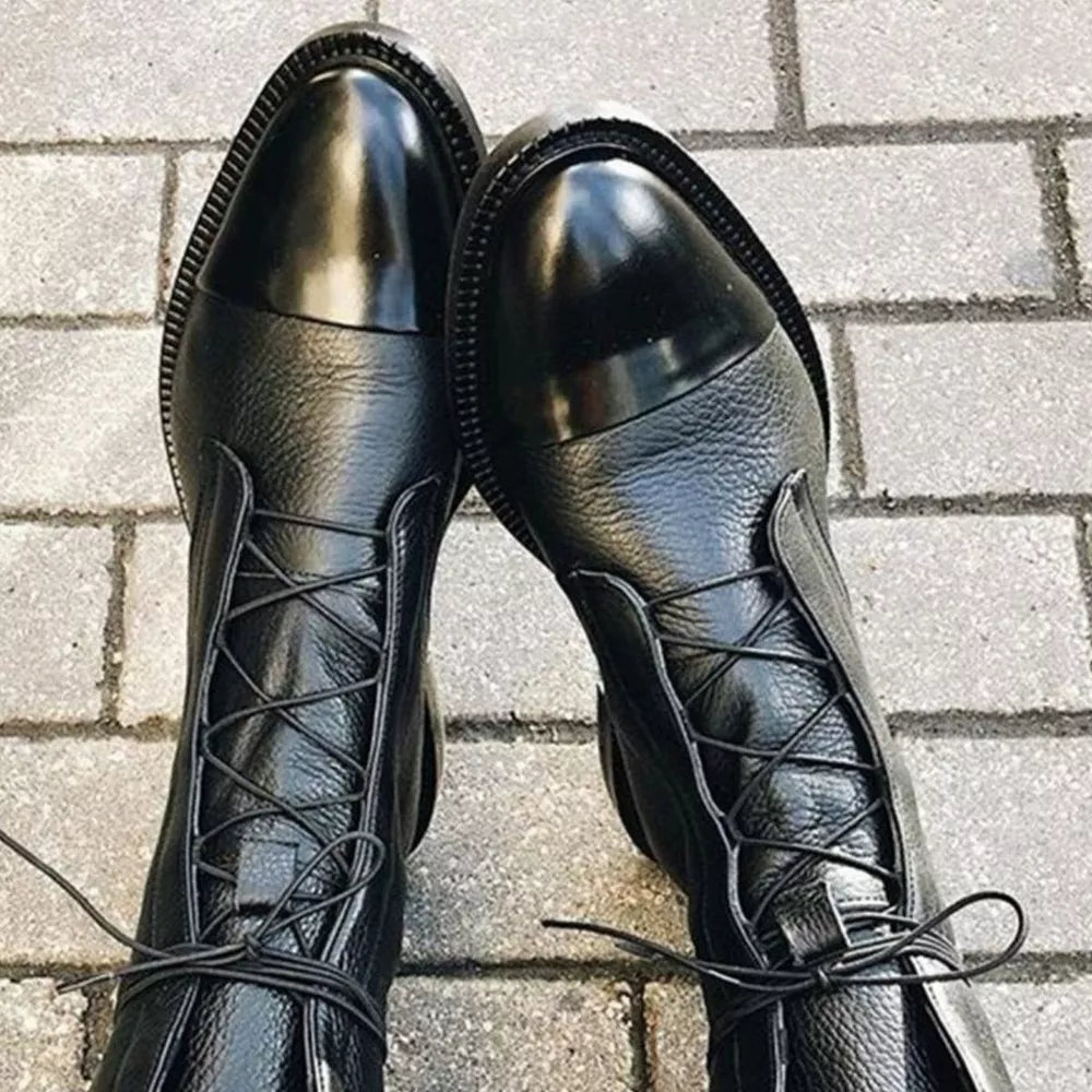 Black leather ankle boots with glossy cap toe and lace-up front.