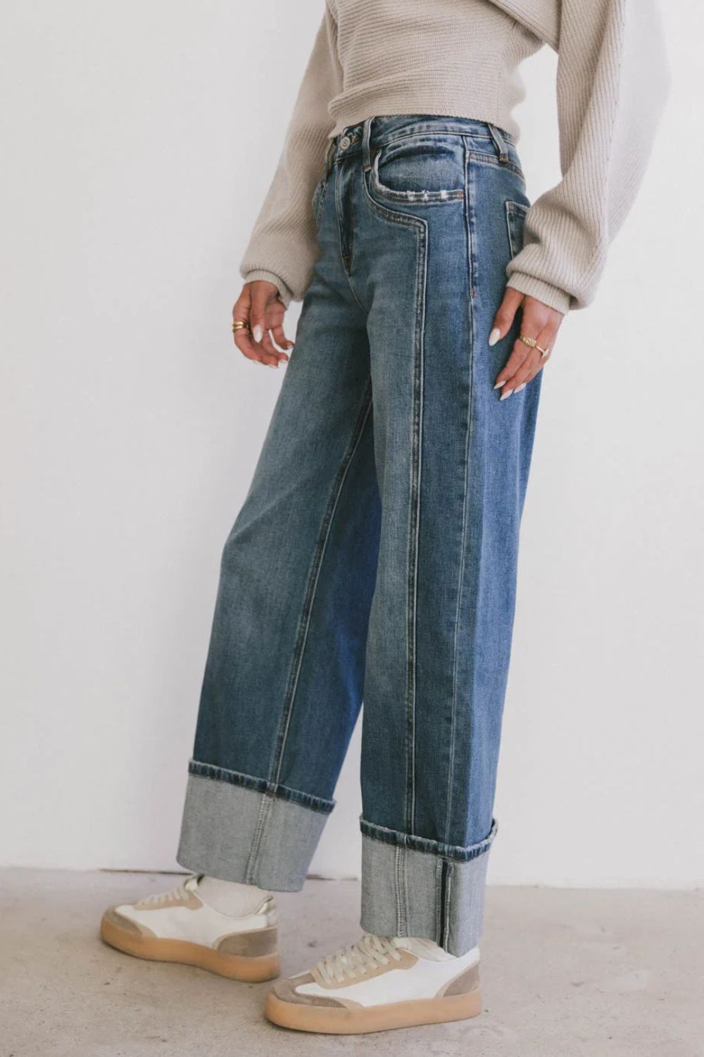 Wide-leg denim jeans in medium wash with contrast cuffs and vertical seam detail.