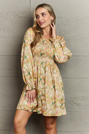 Floral smocked bodice mini dress with long puff sleeves and a square neckline.