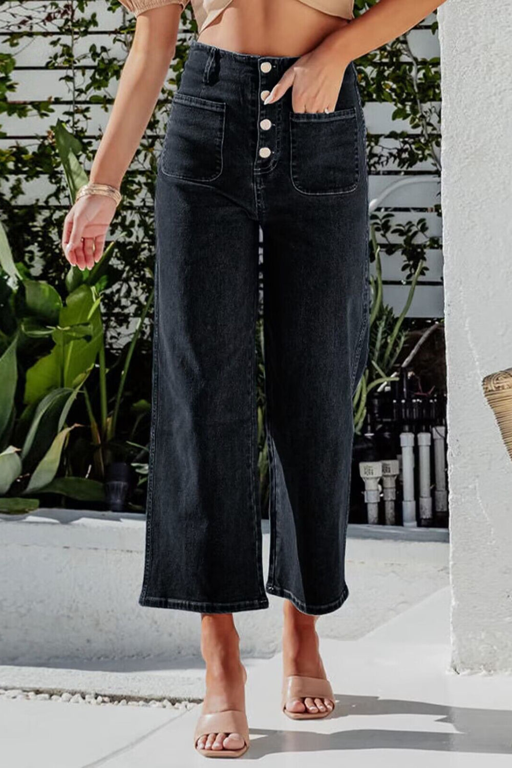 Black button-front cropped wide-leg jeans with patch pockets.