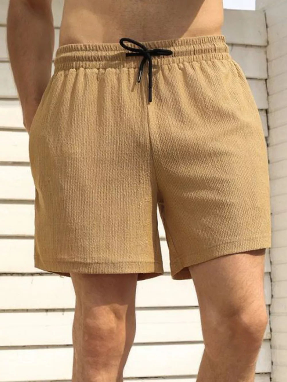 Men's khaki chino shorts with drawstring and textured fabric.