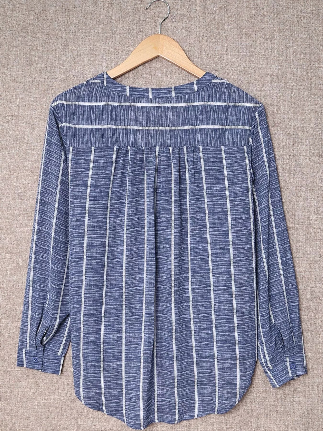Dusty blue striped V-neck buttoned blouse with long sleeves and a relaxed fit.