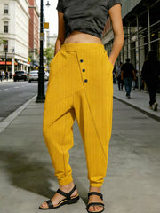Gold harem pants with decorative buttons and pockets, cuffed ankles.