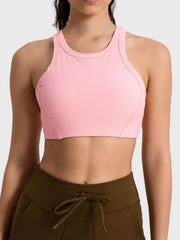 Ribbed blush pink racerback crop top with contour stitching and a high neckline.