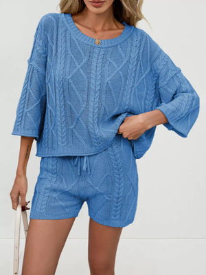 Blue cable-knit two-piece sweater set with crew neck top and drawstring shorts.