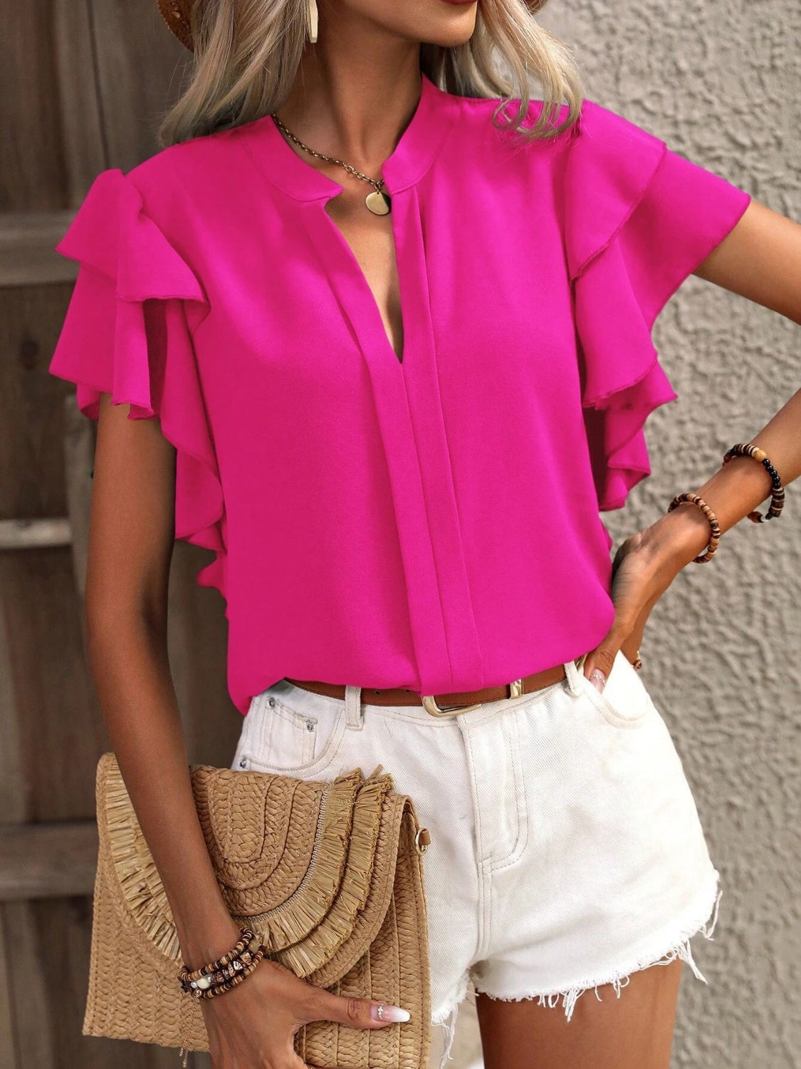 Hot pink blouse with ruffled sleeves and a plunge neckline.