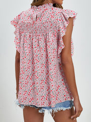 Blush pink floral blouse with smocked yoke and ruffle sleeves.