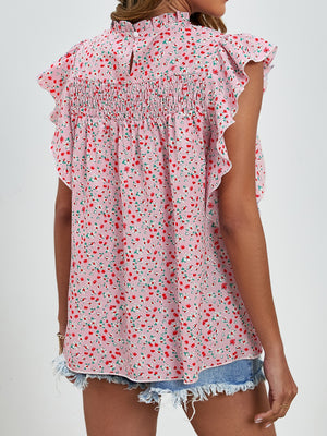Blush pink floral blouse with smocked yoke and ruffle sleeves.