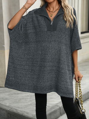 Dark gray knit asymmetrical zip-neck poncho with short sleeves and a collar.
