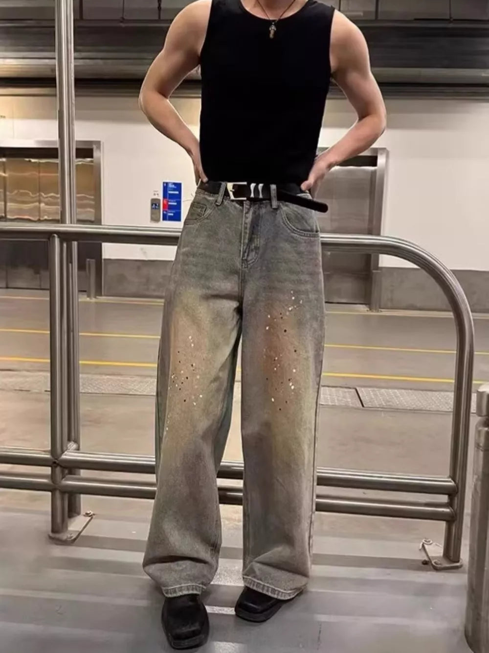 Vintage wash wide-leg jeans with distressed details and paint splatters.